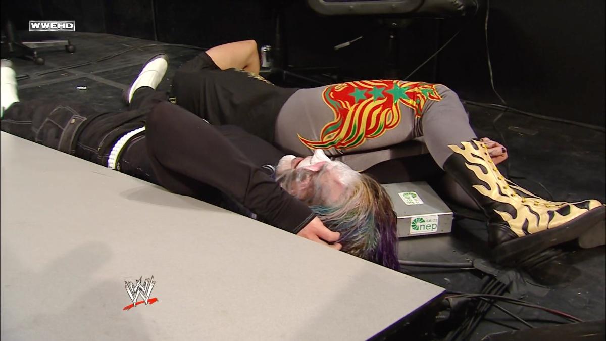 Jeff Hardy and Chavo Guerrero lying down on a destroyed WWE announce table at Royal Rumble 2009