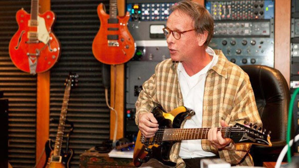 Jim Johnston sitting with an electric guitar in his hands