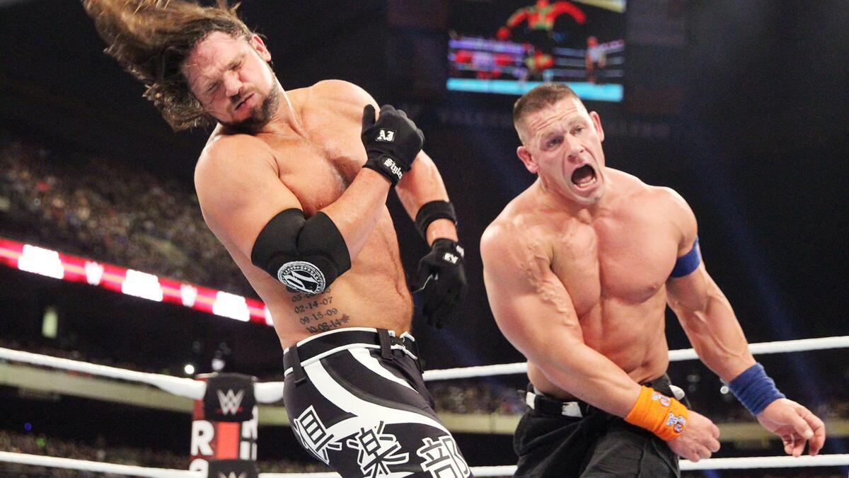 John Cena with his mouth open as AJ Styles falls back in pain at WWE Royal Rumble 2017