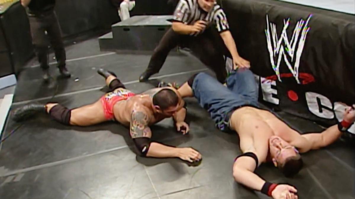 John Cena and Batista lying on the ringside floor at WWE Royal Rumble 2005