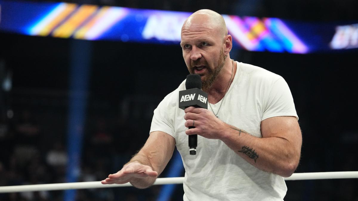 Jon Moxley cutting a promo while wearing a white t-shirt 
