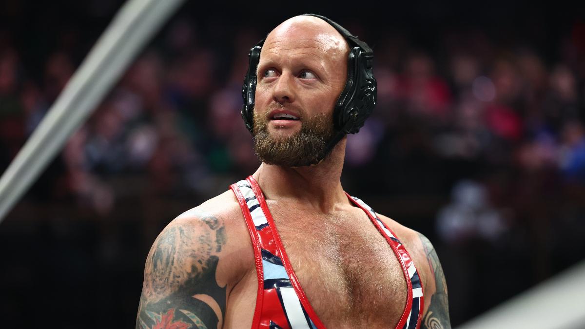 Josh Alexander in wrestling headgear looks out at the audience during a match.