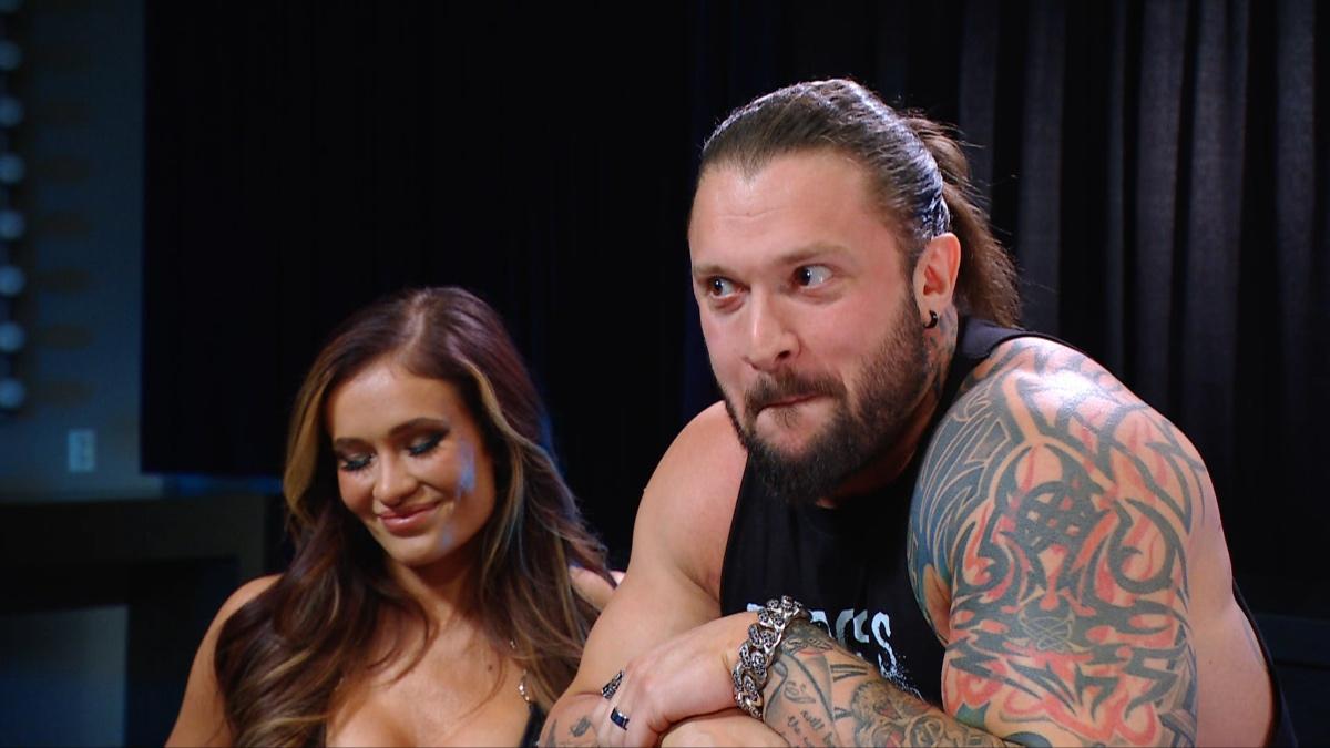 Karrion Kross with a cheeky grin as Scarlett laughs beside him