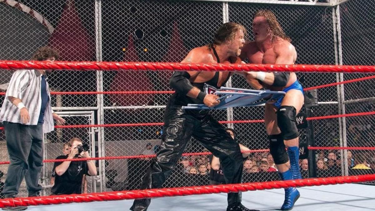 Kevin Nash and Triple H in a ring with Nash holding a chair, Hell in a Cell match in progress.