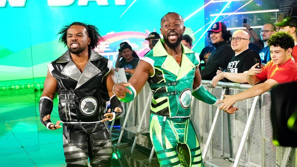 Xaviers Woods in black Power Rangers-inspired attire and Kofi Kingston in green Power Rangers-inspired attire making their way to the ring