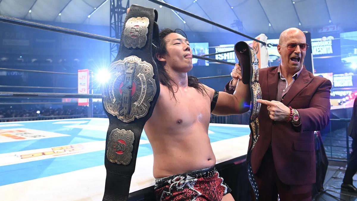 Konosuke Takeshita holding up two title belts with Don Callis at Wrestle Dynasty 2025