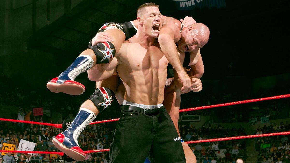 John Cena holds Kurt Angle  on his shoulders in a fireman's carry position during a match on WWE Raw in 2005