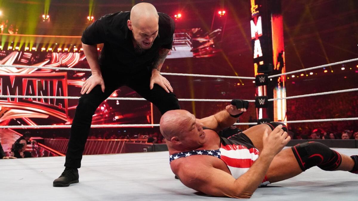 Baron Corbin shouting at a downed Kurt Angle on the mat