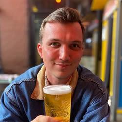 Lewis Howse smiling with a pint of beer