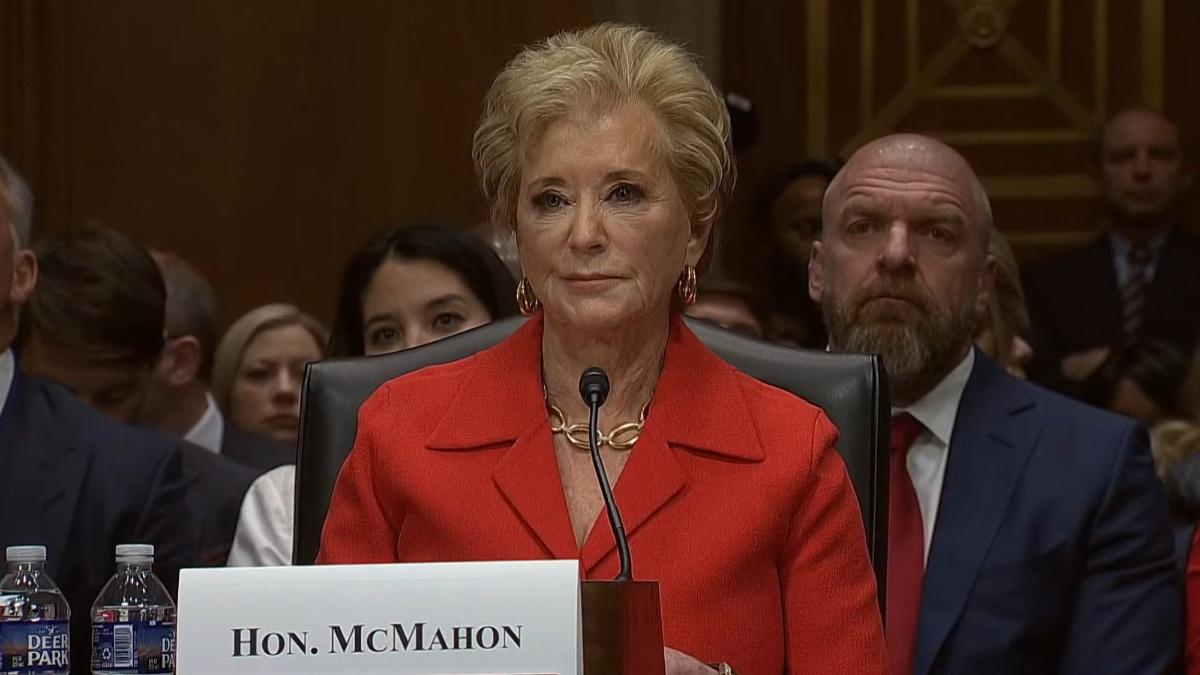 Linda McMahon at her senate confirmation hearing with Triple H sitting behind her