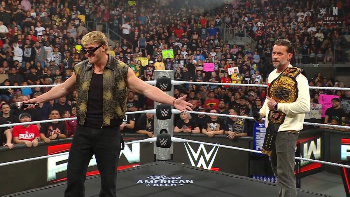 Logan Paul standing on the left with his arms outstretched and CM Punk on the right holding the World Heavyweight Title