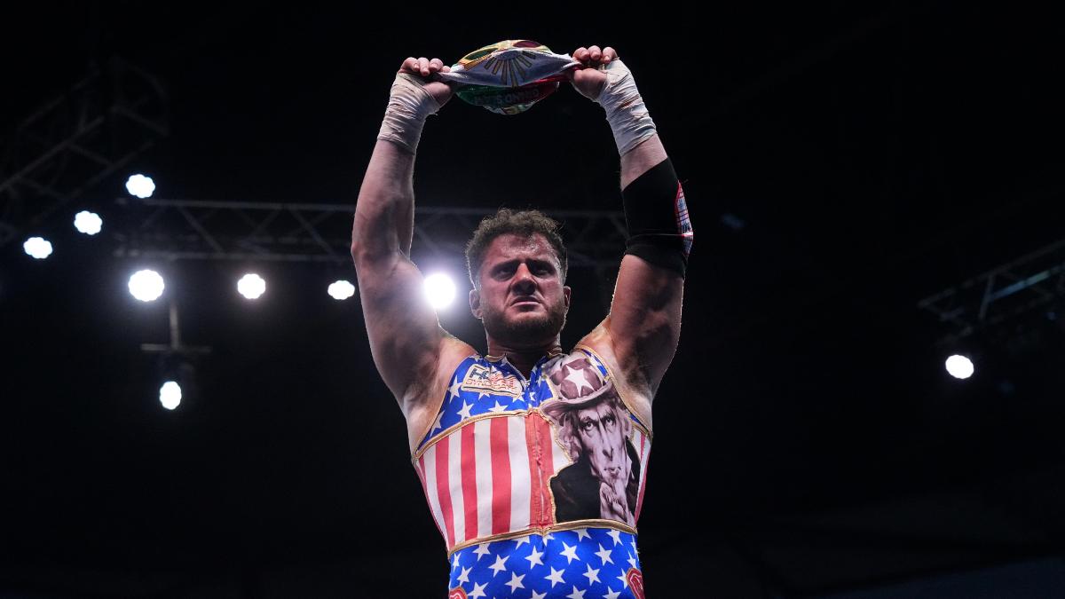 MJF in all-American gear holding up Mistico's mask