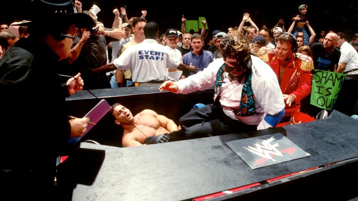 Mankind and Ken Shamrock fighting at the WWE announce table in 1998