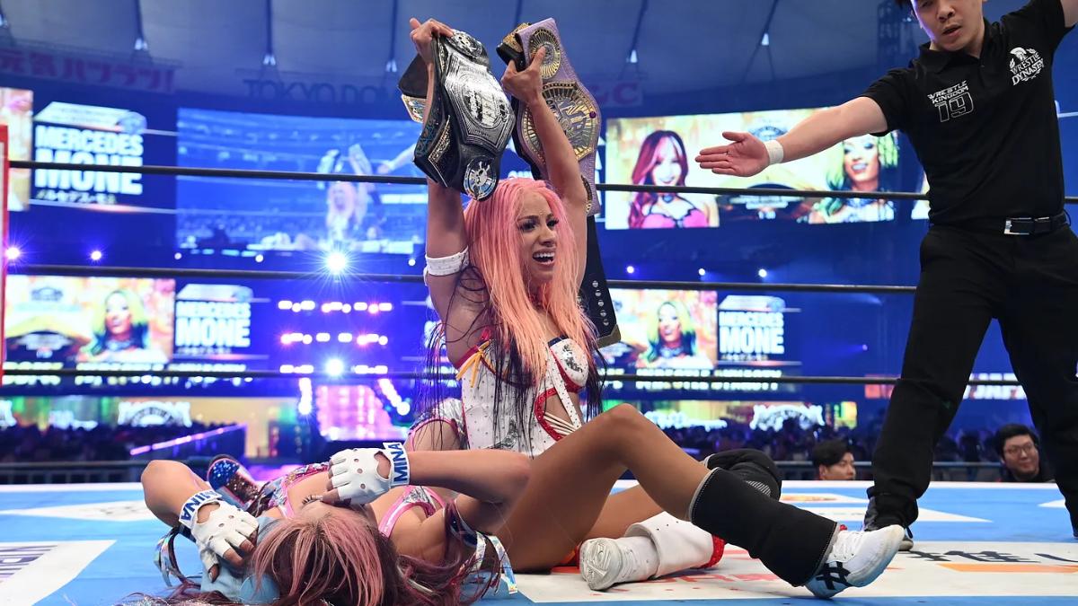 Mercedes Moné holding up the Southside Women's Title and NJPW STRONG Women's Title