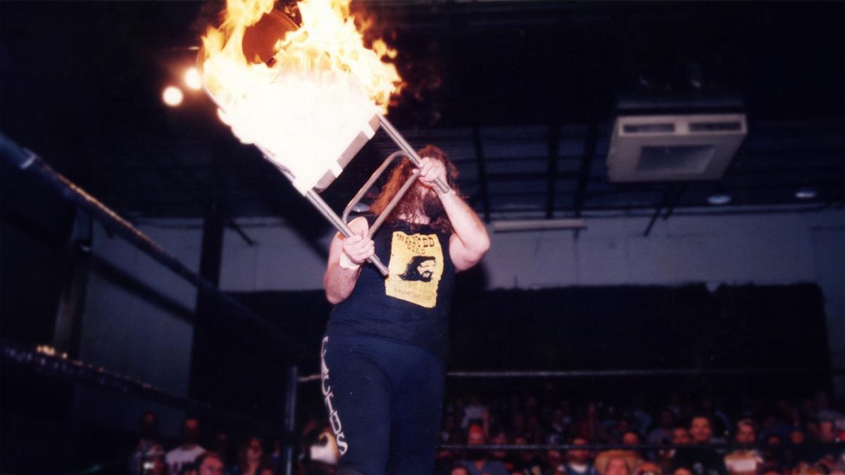 Mick Foley holding a flaming chair