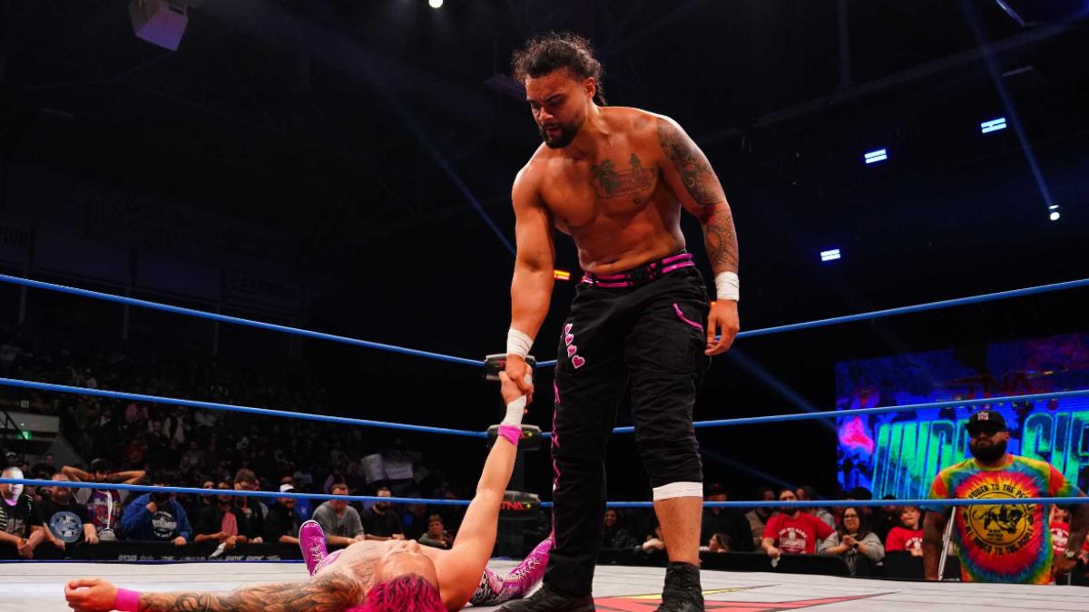 Mike Santana shaking KC Navarro's hand, who is lay on the ring mat, at TNA Under Siege 2025