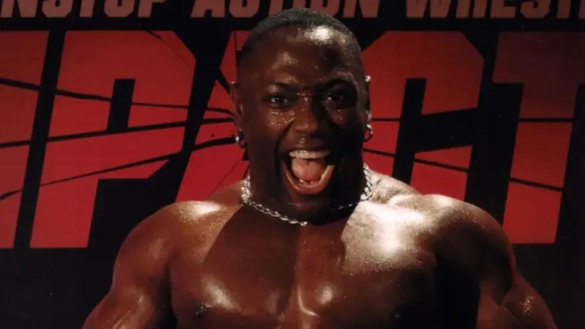 Monty Brown shouting in front of TNA IMPACT logo