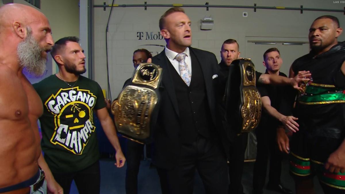 Nick Aldis holding the WWE Tag Team Titles