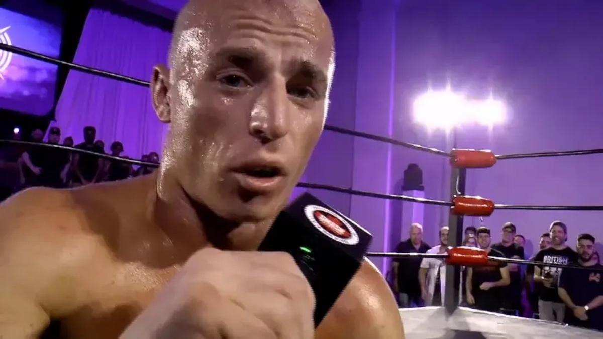 Paul Robinson holding a microphone in PROGRESS Wrestling