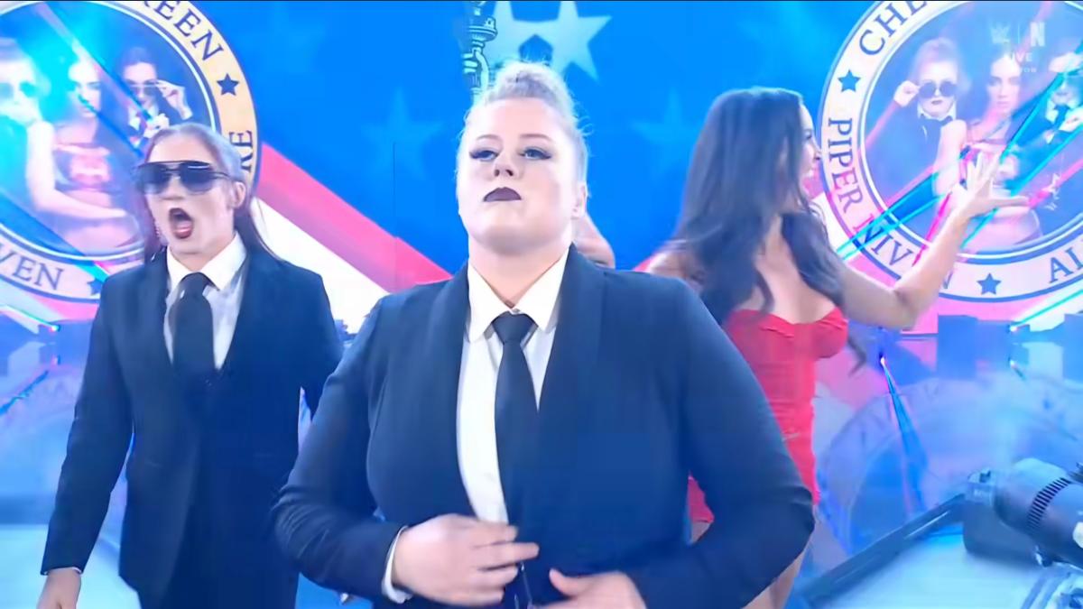 Piper Niven accompanied by Alba Fyre and Chelsea Green walks to a wrestling ring