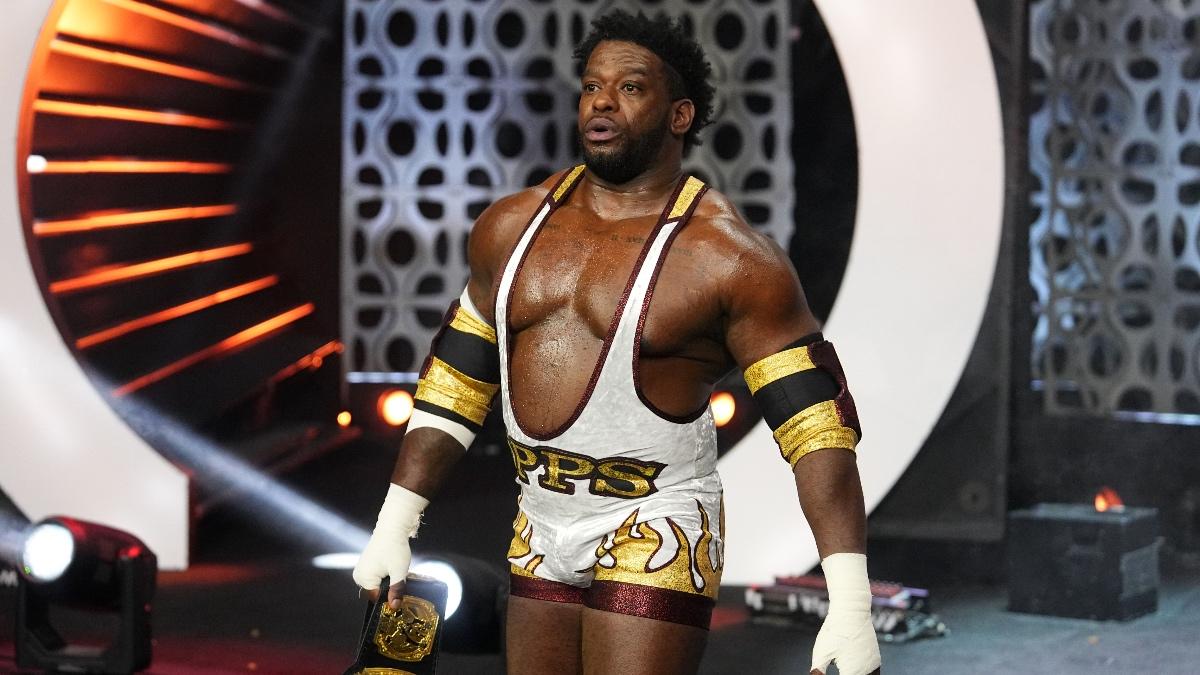 Powerhouse Hobbs in a white and gold singlet walking to the ring