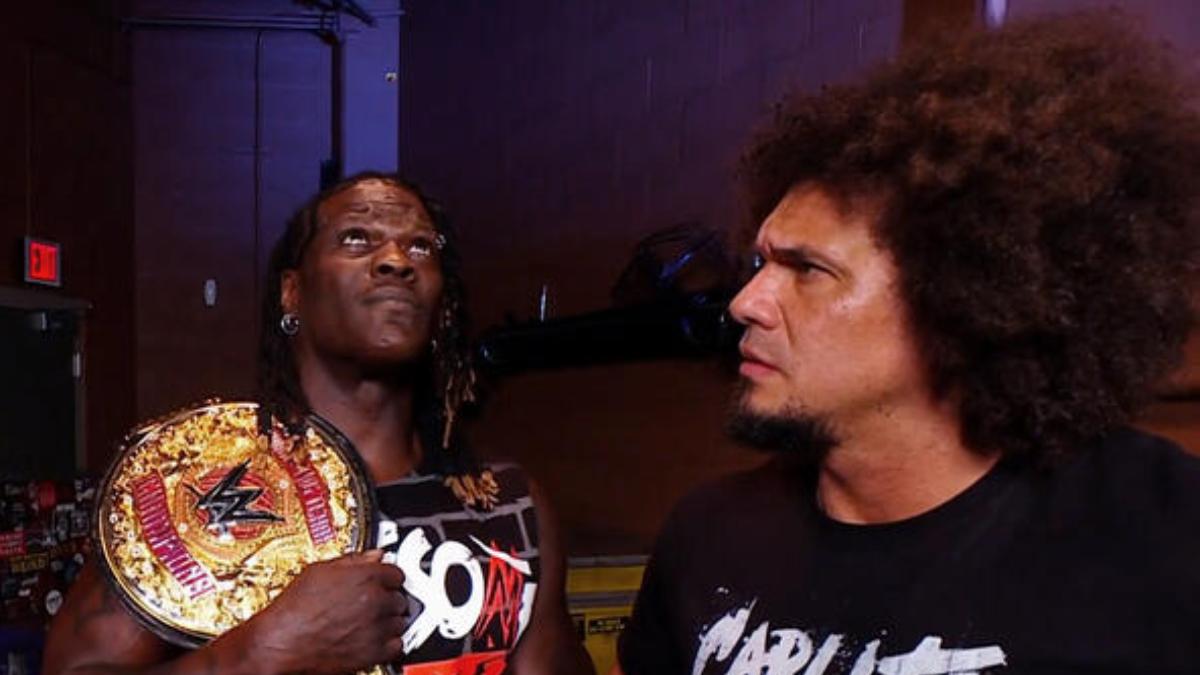 R-Truth looking up away from Carlito as Carlito stares right at him on WWE Raw