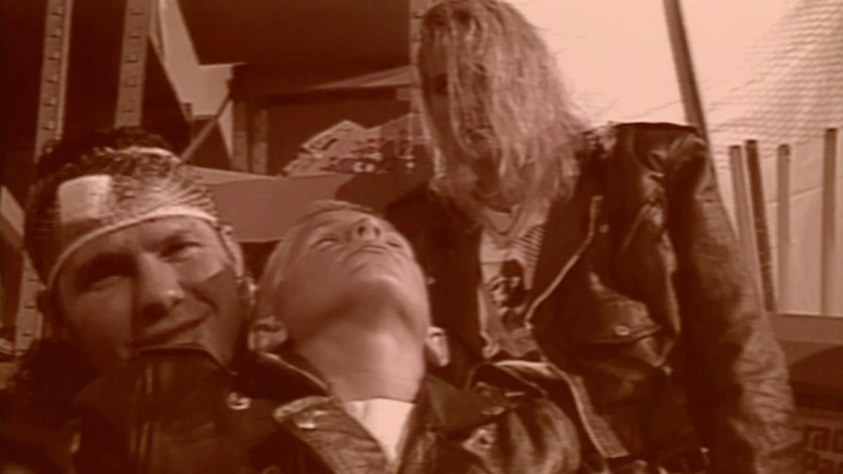 Tyler pulls the Raven post as Raven laughs behind him and Lori stands above them both in the background