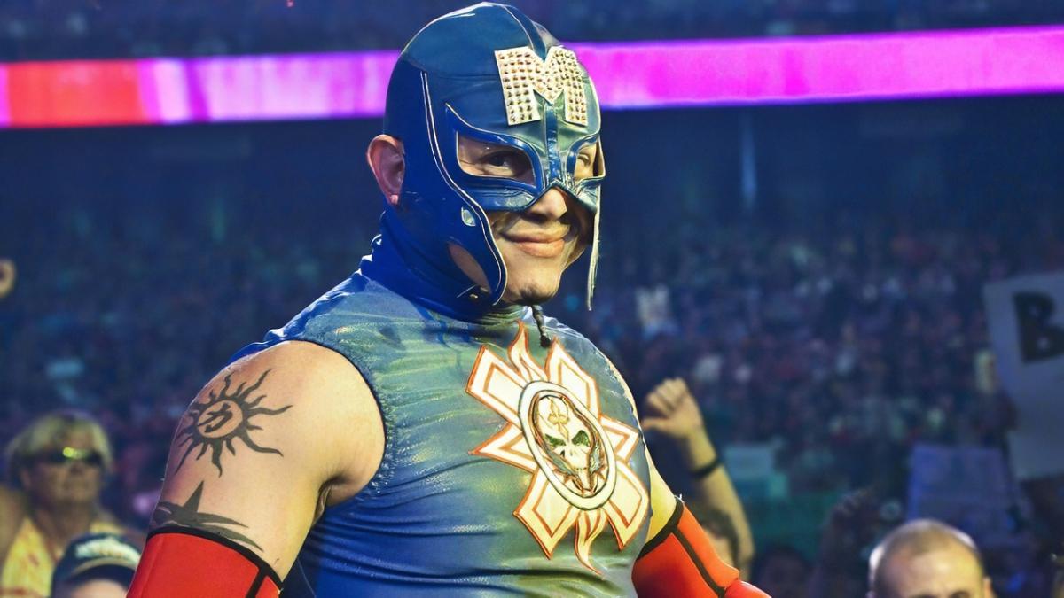 Rey Mysterio smiling at the camera on his way to a wrestling match in an outfit paying homage to Captain America