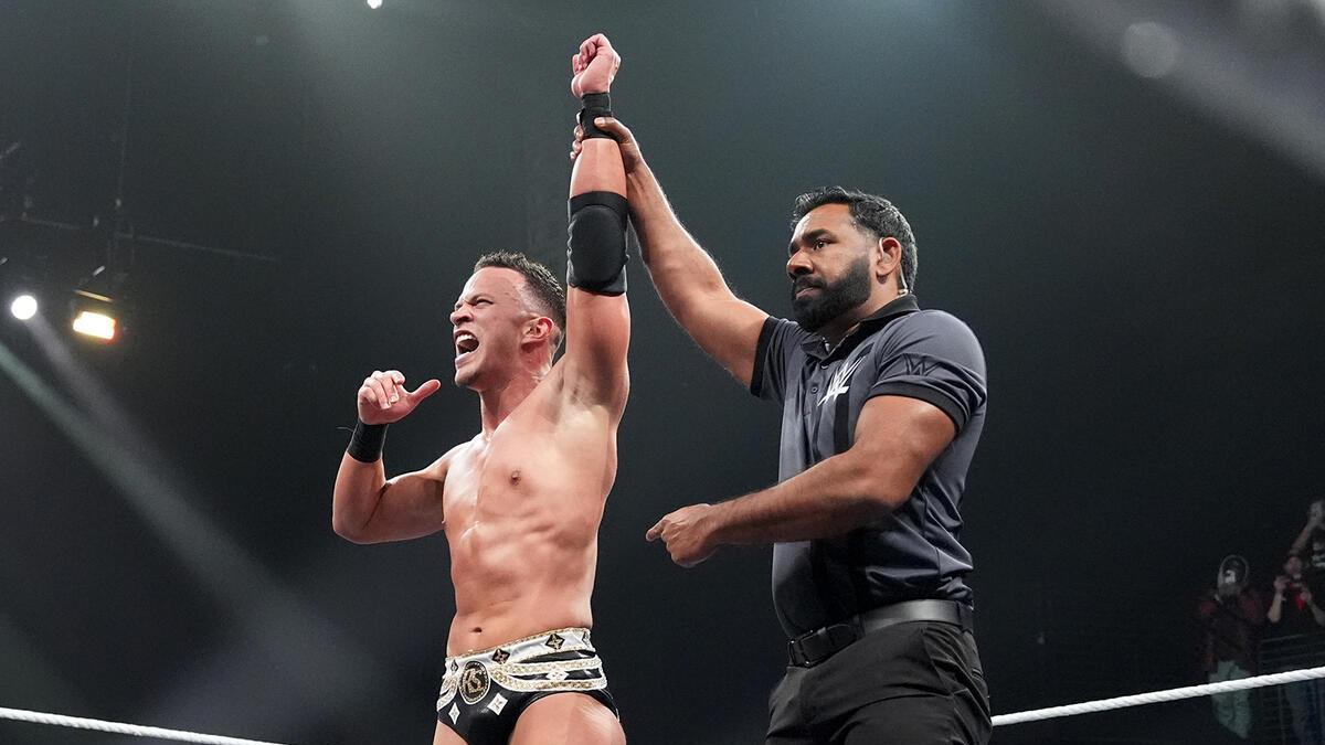 Ricky Starks celebrating the win in his WWE in-ring debut, having his hand raised by the referee