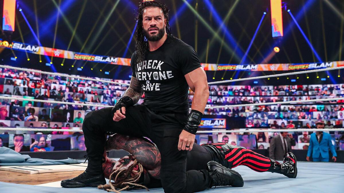 Roman Reigns kneeling above Bray Wyatt at WWE SummerSlam 2020