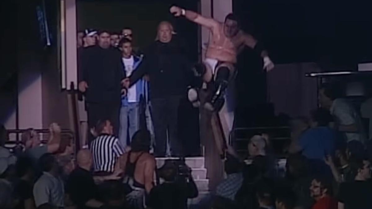 Samoa Joe delivering a kick to Sting after jumping through the air onto some stairs