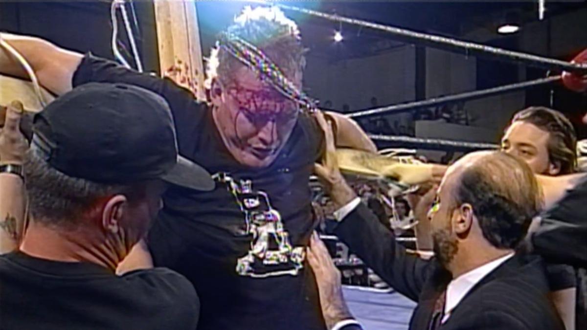 Sandman being helped on the cross by Tod Gordon and others at ECW High Incident