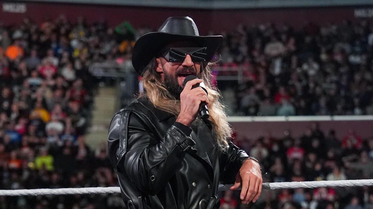 Seth Rollins in black leather jacket with leather cowboy hat and black sunglasses