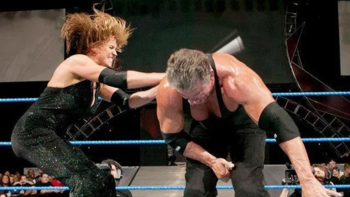 Stephanie McMahon hitting Vince McMahon with a lead pipe on the back at WWE No Mercy 2003