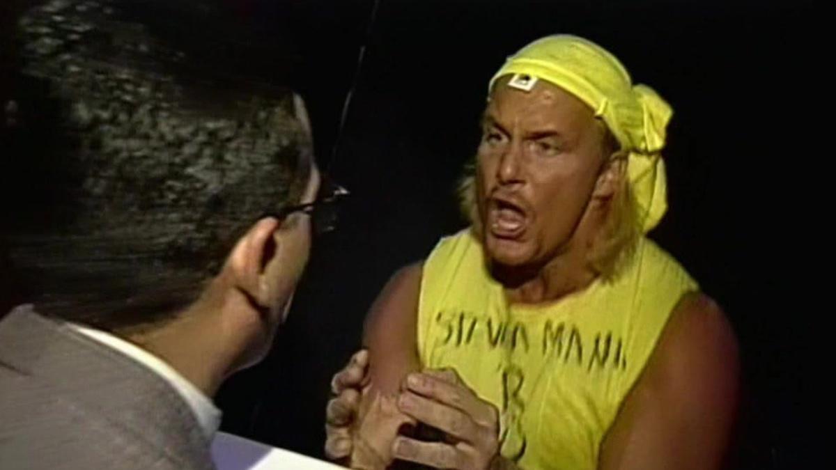 Steve Austin in a yellow vest and bandana to mock Hulk Hogan as an interview tries to speak to him
