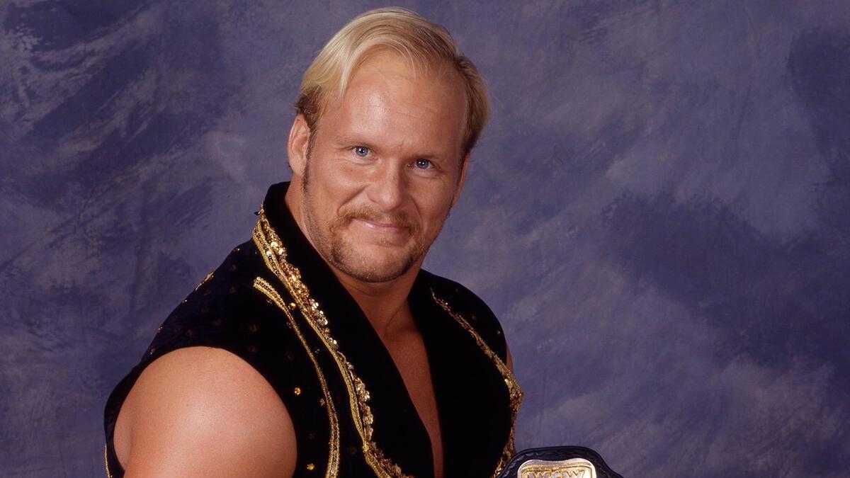 Stunning Steve Austin smiling at the camera while wearing a black and gold vest