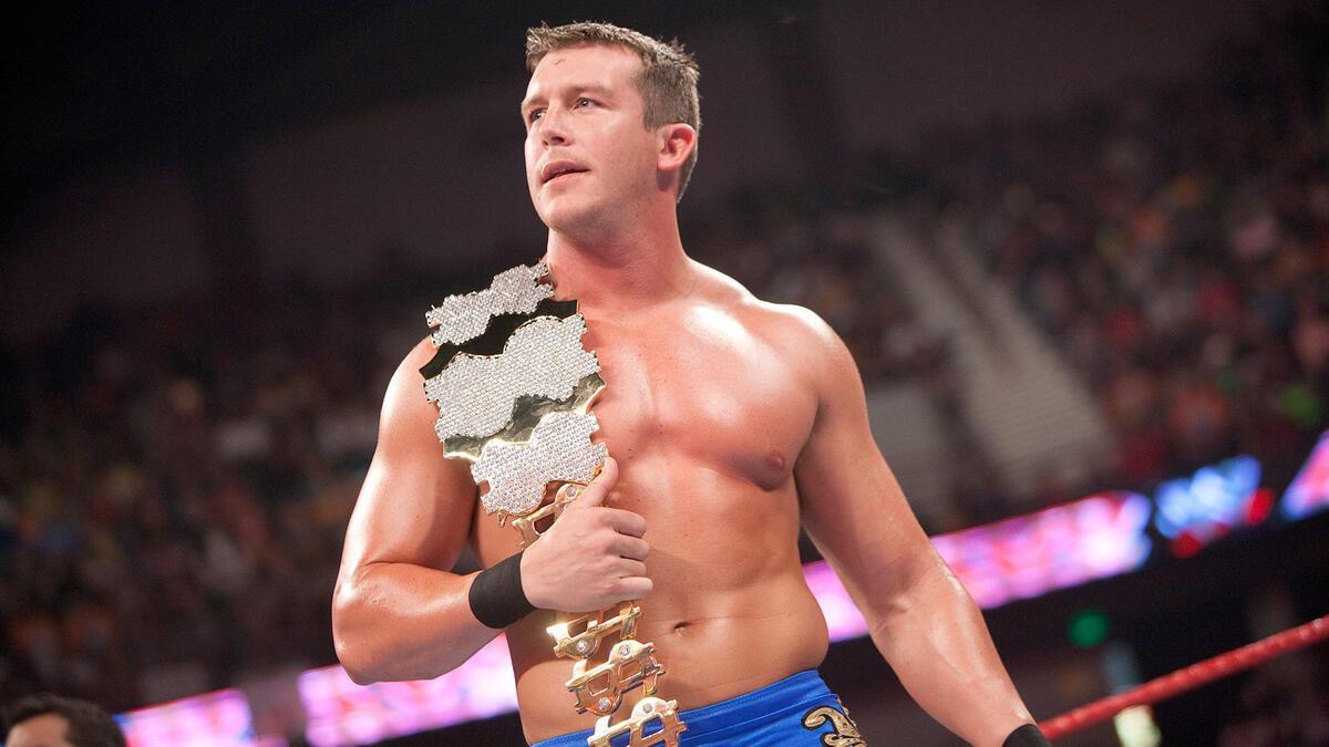 Ted DiBiase Jr. stands in the ring with the Million Dollar Championship belt draped over his shoulder