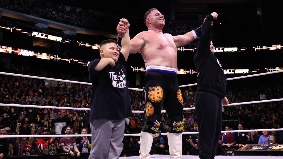 Big Boom AJ, Little Justice and The Rizzler, AKA the Cocsto Guys, celebrate in the ring following AJ's victory at AEW Full Gear 2024