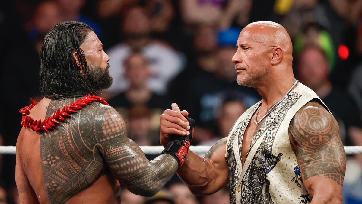 The Rock and Roman Reigns holding hands at WWE Raw Netflix premiere