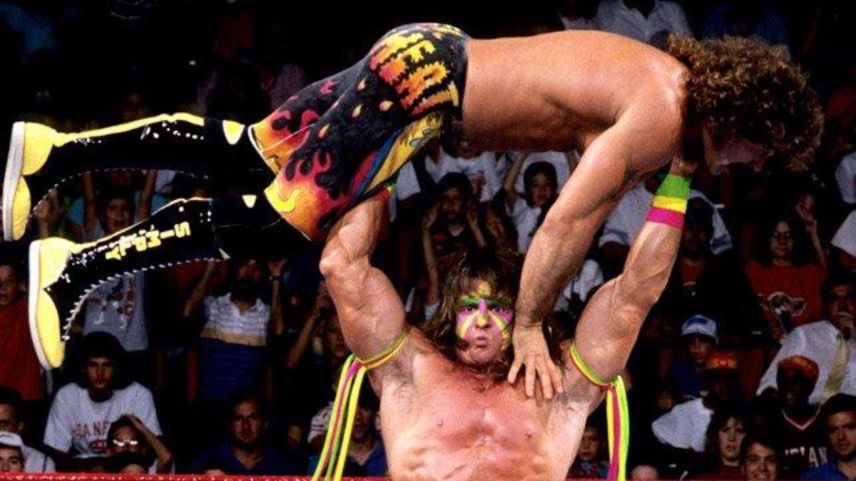 The Ultimate Warrior holding Rick Rude up for a Gorilla Press Clam at WWE SummerSlam 1989