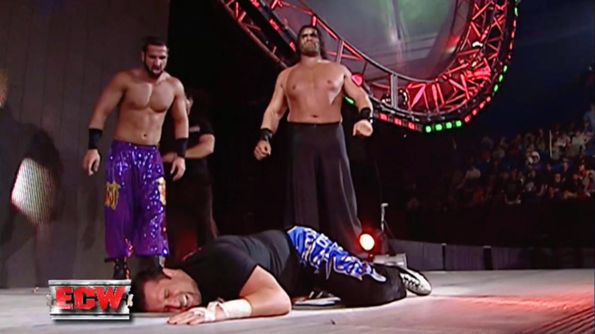 Tommy Dreamed lying down as Great Khali and Daivari stand above him