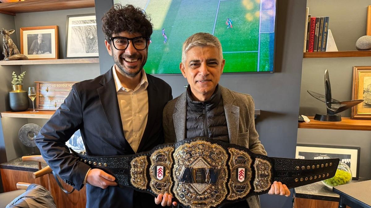 Tony Khan standing with Sadiq Khan, who is holding an AEW World Title belt with Fulham FC sideplates