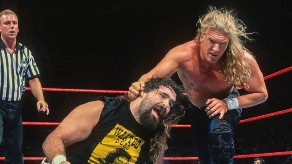 Triple H grabs Cactus Jack by the hair during one of their WWE matches from 1997