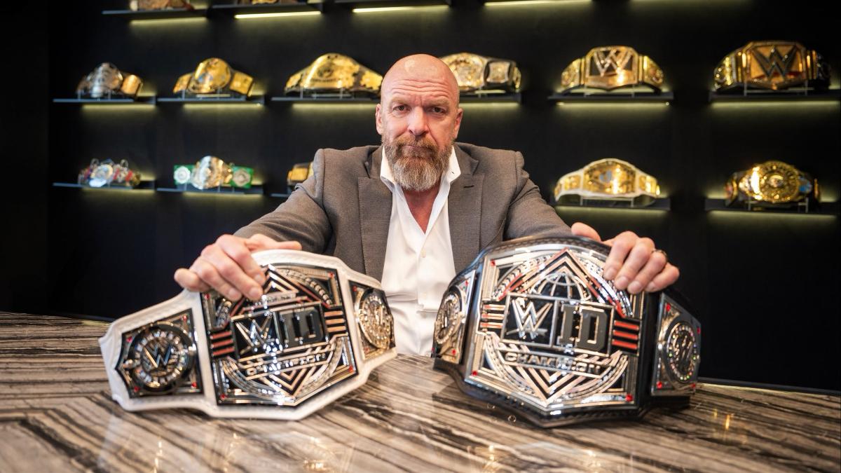 Triple H sat down in a grey suit, white shirt and no tied with the WWE ID title belts