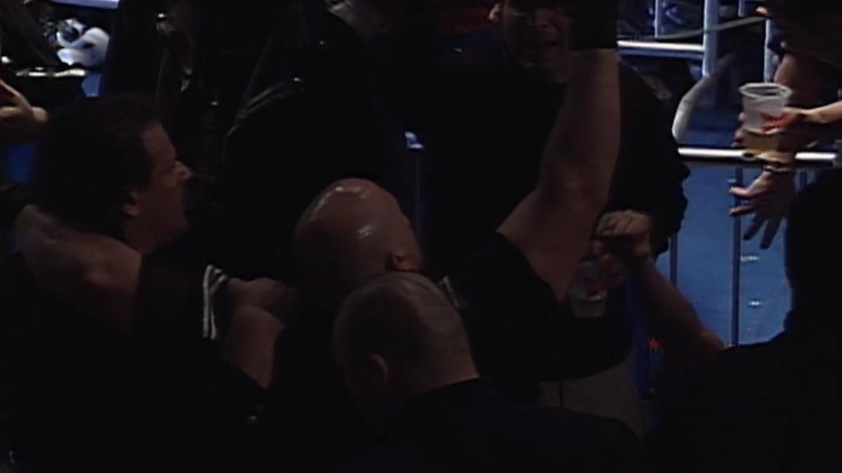 Vic Grimes raising his arm as he's held up by two men at ECW Living Dangerously 2000