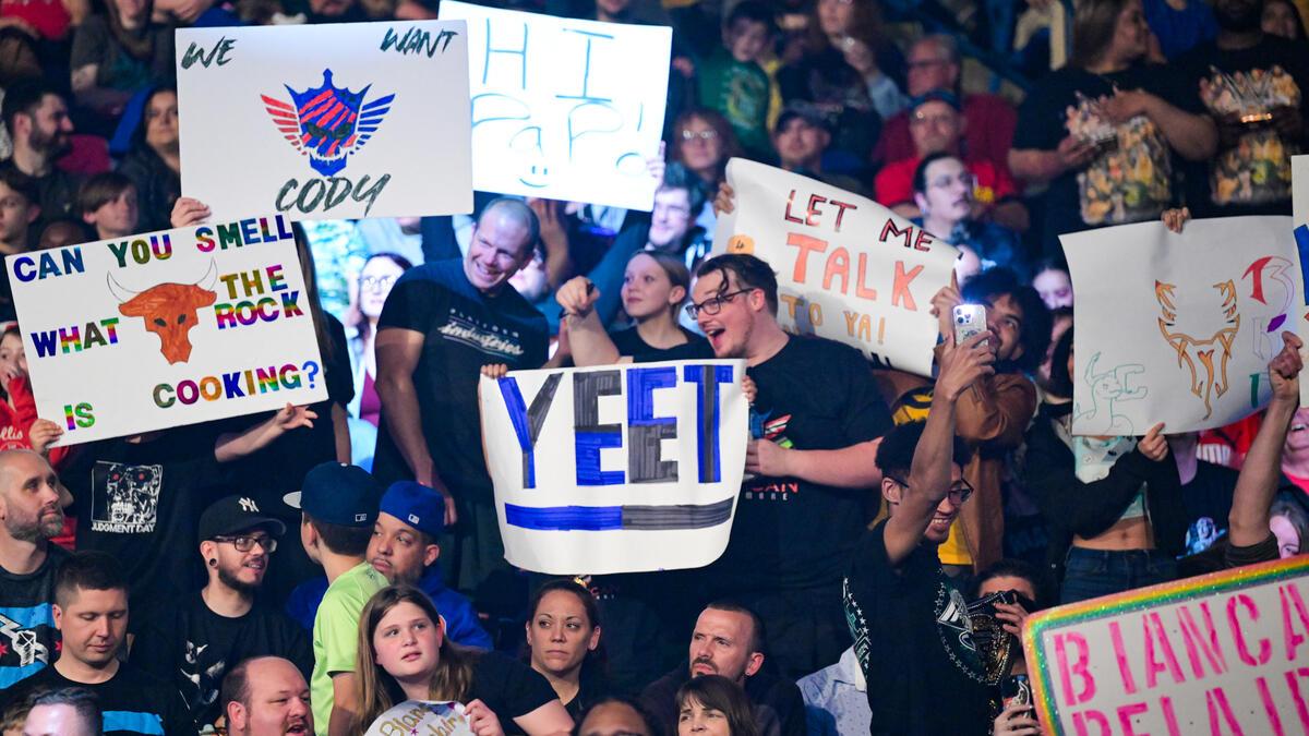 WWE fan signs for Jey Uso, The Rock, and Cody Rhodes in May 2024