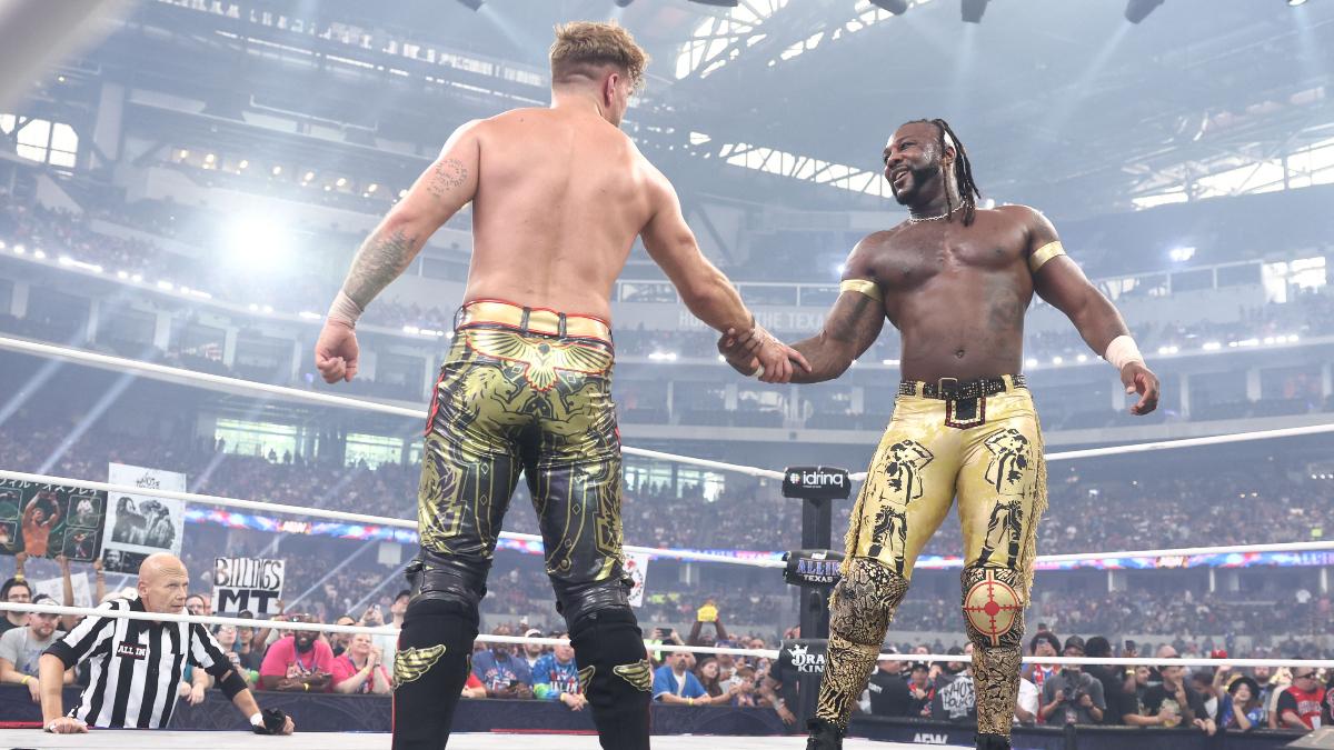 Will Ospreay shakes Swerve Strickland's hand in a wrestling ring in front of an audience