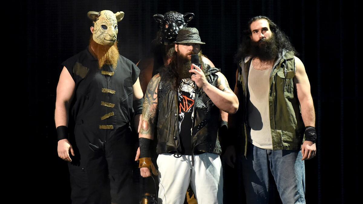 Bray Wyatt standing in the middle cutting a promo with Erick Rowan in a white sheep mask to his left, Braun Strowman in a black sheep mask behind, and Luke Harper with a black bear to his right