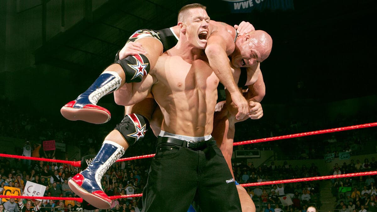 John Cena holds Kurt Angle on his shoulders in a fireman's carry position during a match on WWE Raw in 2005