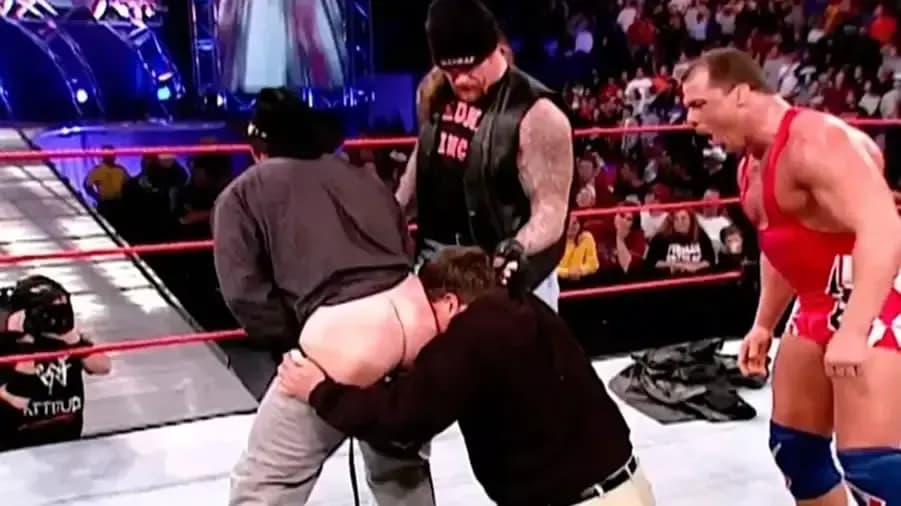 https://cultaholic.com/files/images/6b2e5edc27c26a68d27fe5ba6225a5bf3018d964-the-undertaker-kurt-angle-vince-mcmahon-jim-ross-kiss-my-ass.jpg